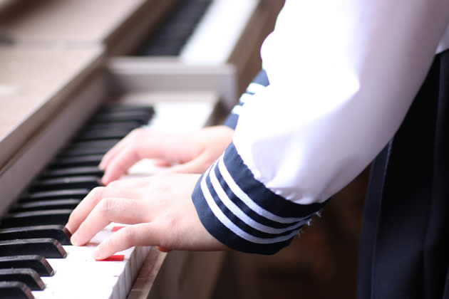 女の子がピアノを演奏している手元のイメージ